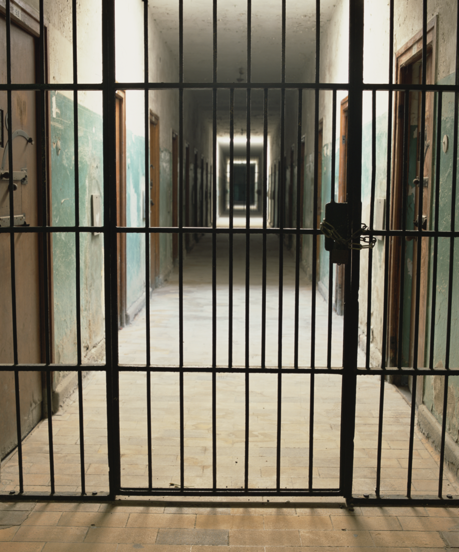 Photo by artist Andres Serrano titled 'Bunker II, Dachau'. It features a concentration camp corridor through iron bars.