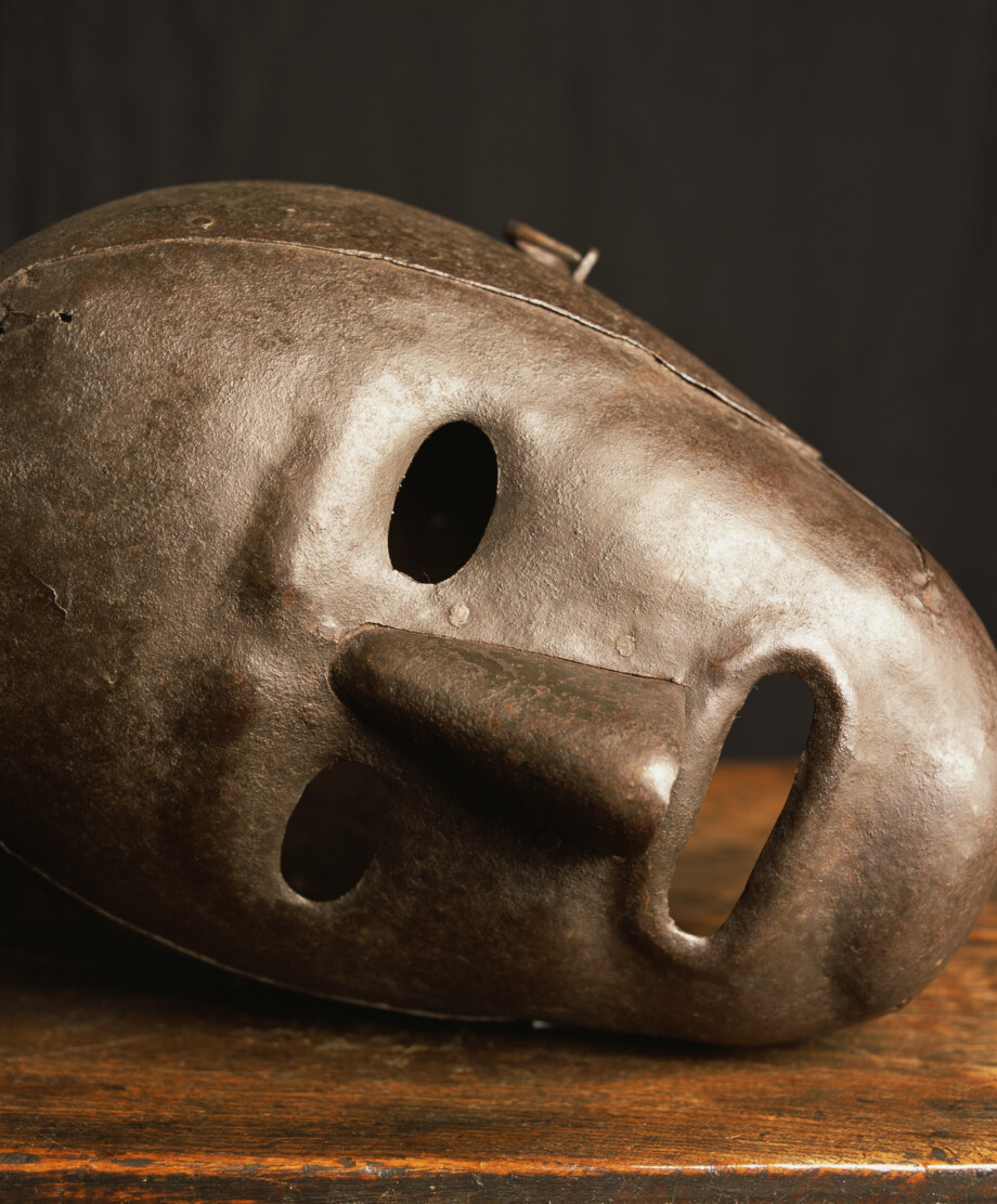 A photo by the artist Andres Serrano titled 'Scold's Bridle IV, Hever Castle, Kent, UK', depicting a heavy metal mask used to torture individuals.