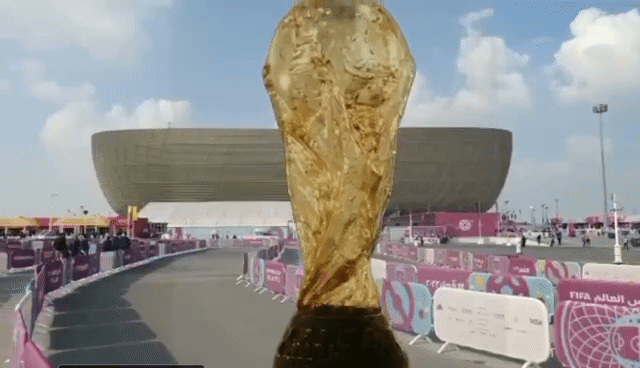 This image depicts Andrei Molodkin's ai-version of his sculpture, The Fifa World Cup Filled With Qatari Oil. The artwork is floating on a mobile screen in front of the exterior of the Lusail Stadium in Qatar during the build-up to the World Cup Final.